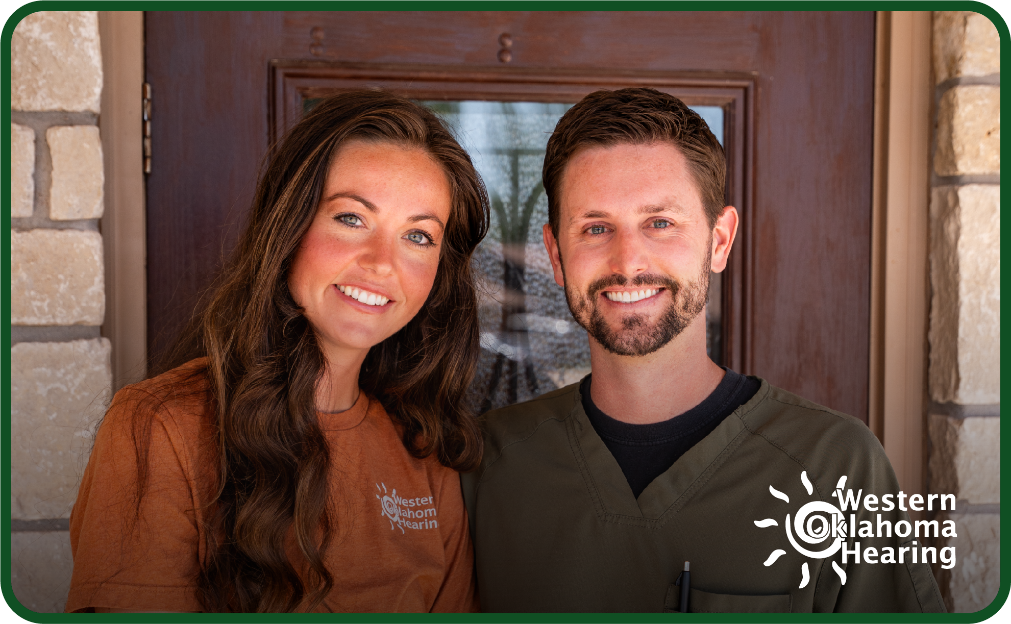 Two audiologists standing in front of a door. 