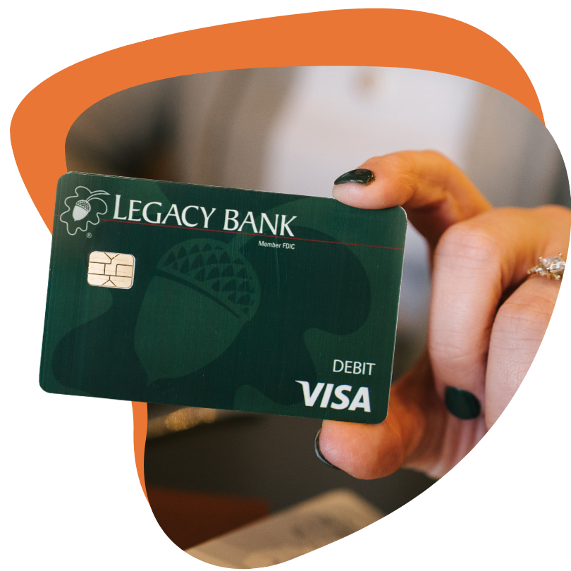 Hand holding a green debit card