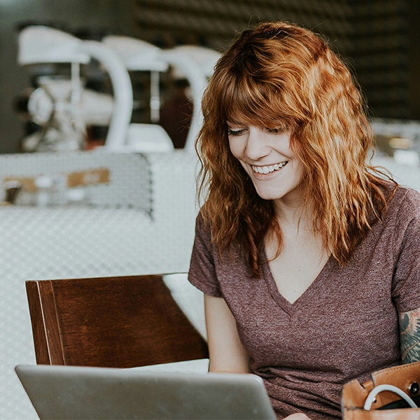 Girl with Red Hair looking at a laptop screen.